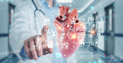 Picture of a Physician putting his finger up to a clear screen that is showing a module of a heart and health related icons around it.