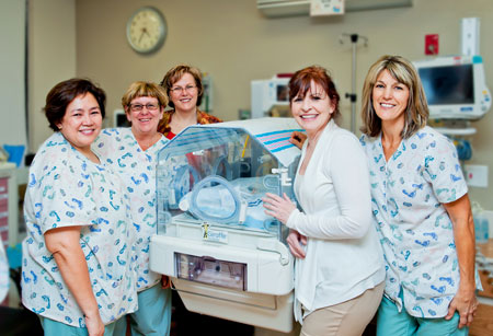 Picture of five female Nurses standing in the Hospital baby nursery.