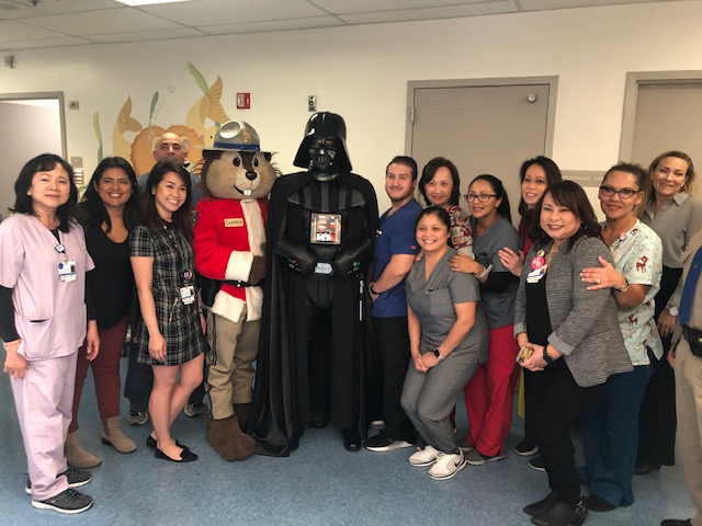 Squirrel Ranger and Darth Vader taking a picture with Whittier Hospital's Pediatric Sub Acute Unit Staff