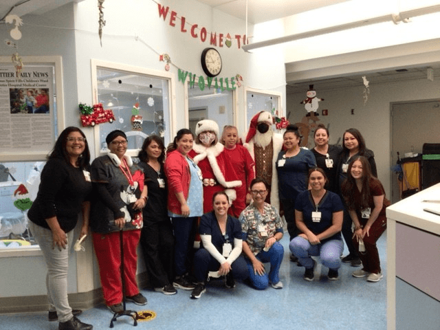 Hospital Medical Staff taking a group picture with Mr. & Mrs. Claus
