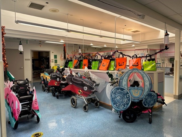 Pediatric Subacute Unit Floor showing five wheelchair costumes and halloween bags in front of Nurse's Station